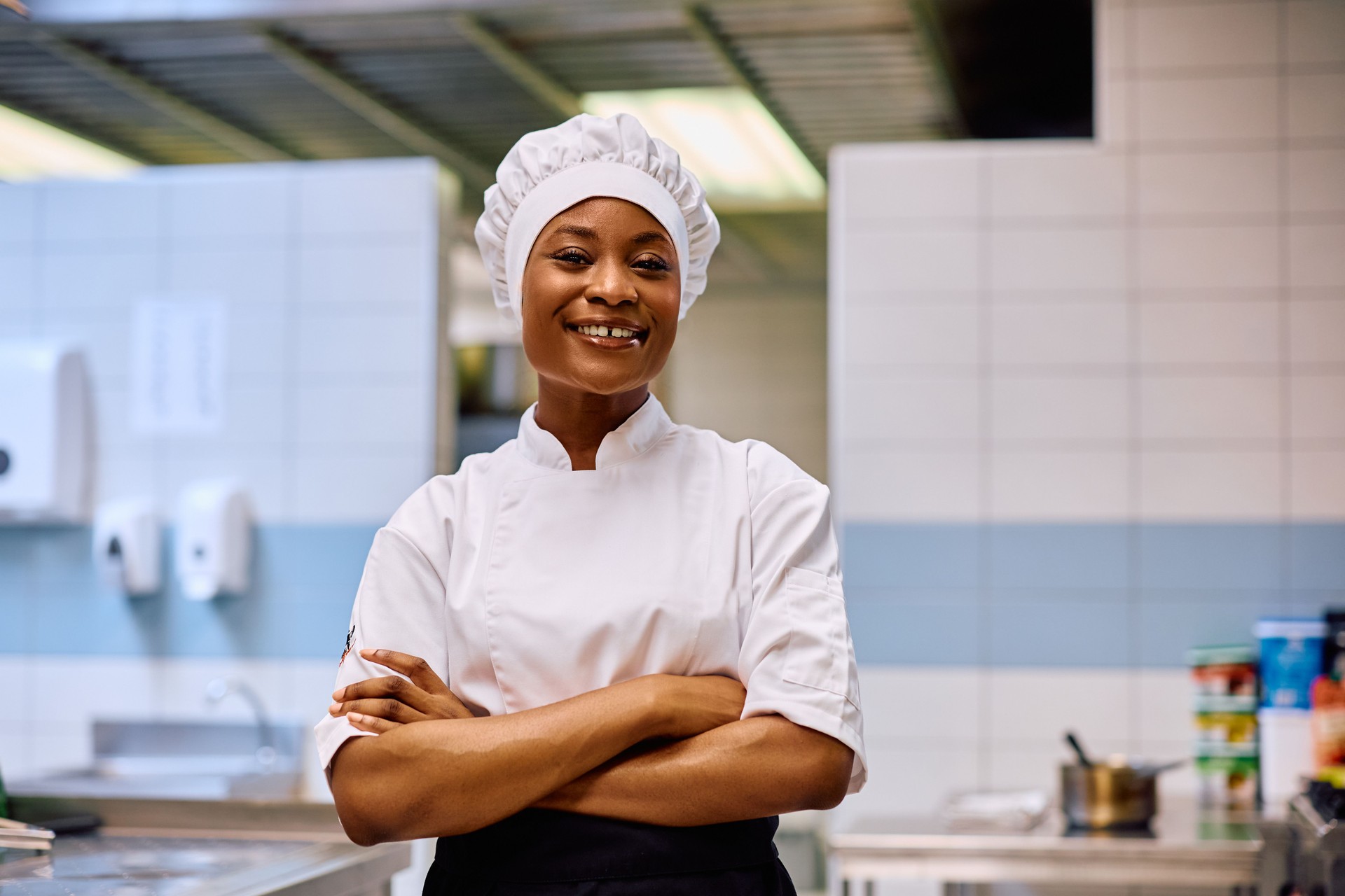 Confident black female chef in the kitchen looking at camera.